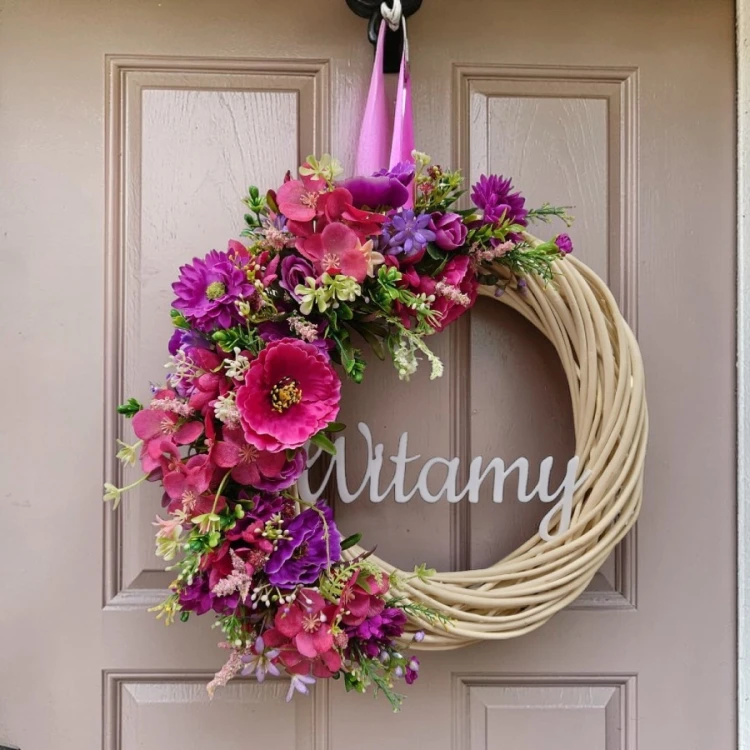 wianek wiklinowy na drzwi z napisem "witamy" z różowo fioletowymi kwiatami, średnica 33cm , napis biały akrylowy, na tle drzwi