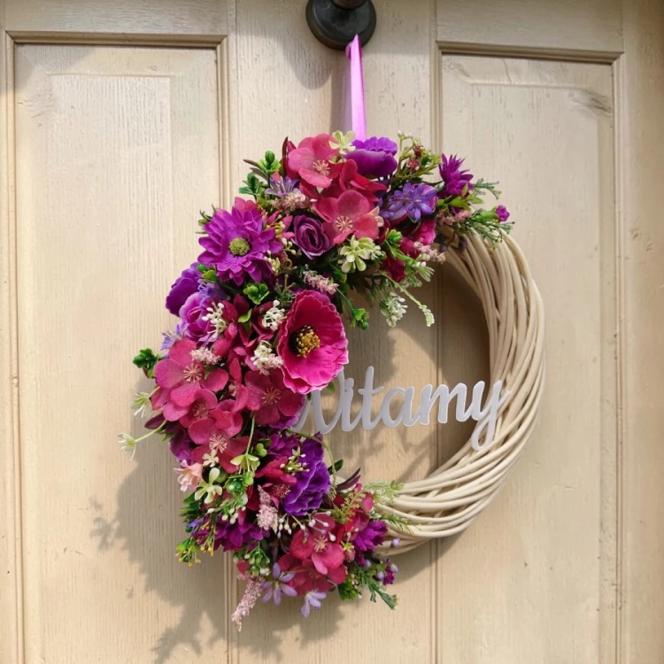 wianek z różowo-fioletowymi kwiatami na tle jasnych drewnianych drzwi, średnica 33cm